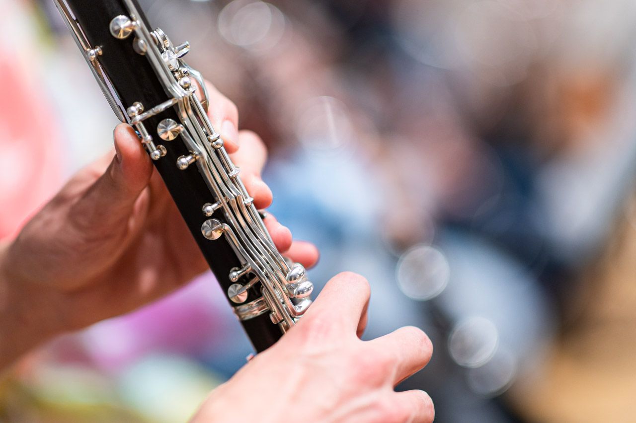 Eine Person spielt Klarinette, es sind nur ihre Hände und das Instrument zu sehen
